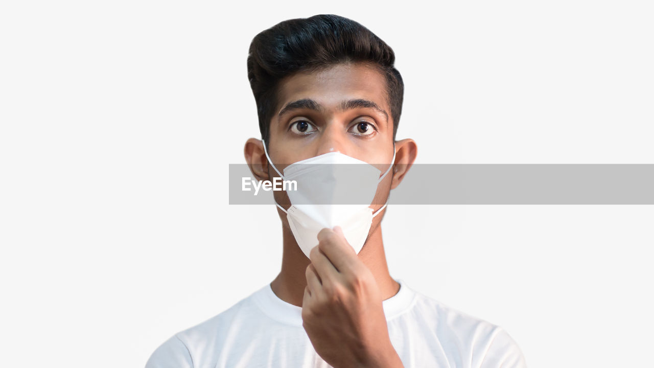 PORTRAIT OF YOUNG MAN WEARING WHITE BACKGROUND