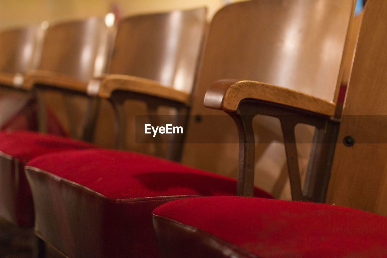 Close-up of wooden chairs at auditorium