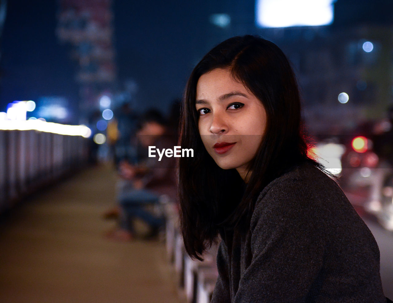 Portrait of woman standing outdoors at night