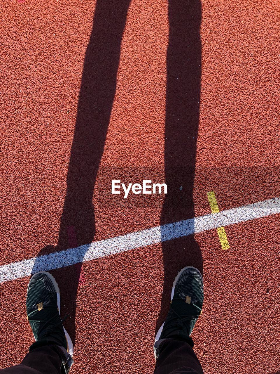 Low section of person standing on running track