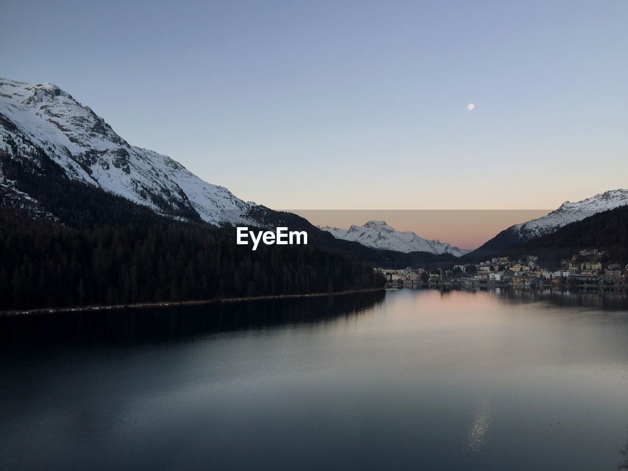 Scenic view of lake and snowcapped mountains against clear sky