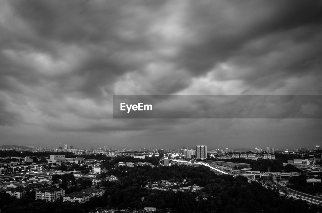 Aerial view of cityscape against storm clouds