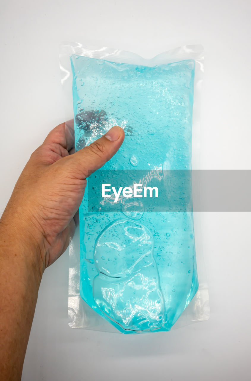 CLOSE-UP OF PERSON HAND HOLDING ICE CREAM IN GLASS