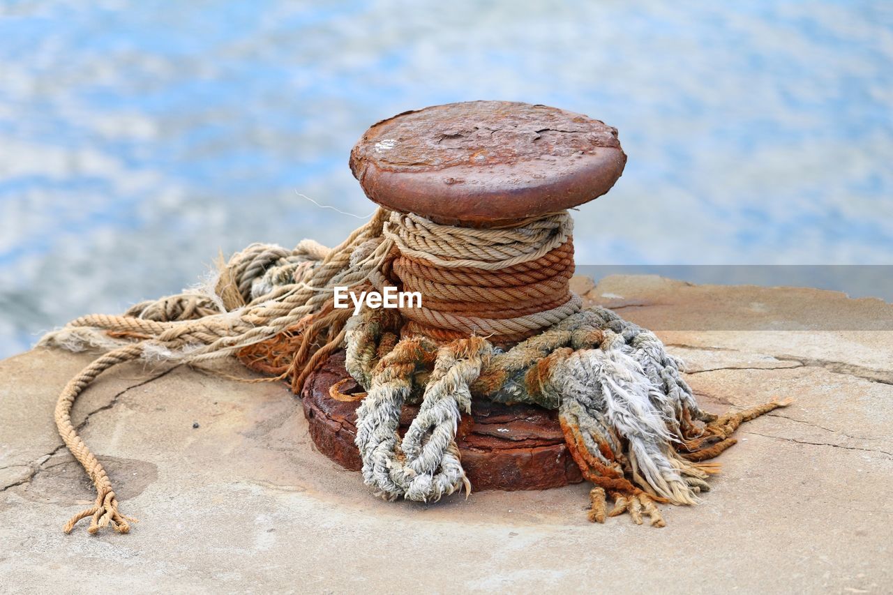 Close-up of rope tied on rusty pier