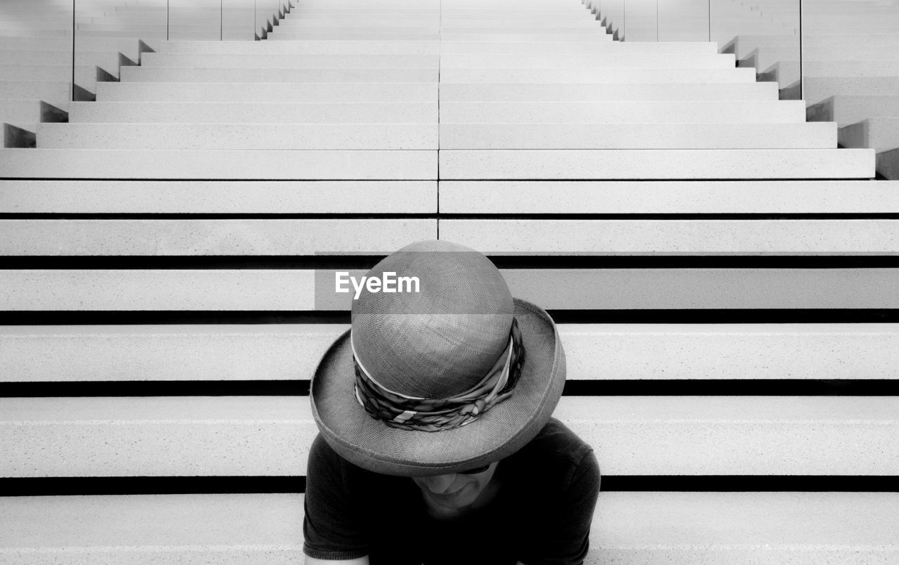 Woman wearing hat sitting on steps