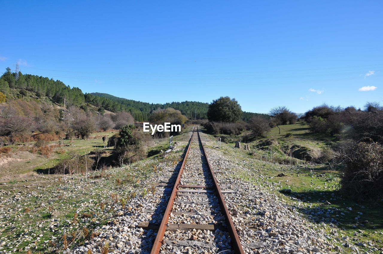 Railroad tracks on field against sky