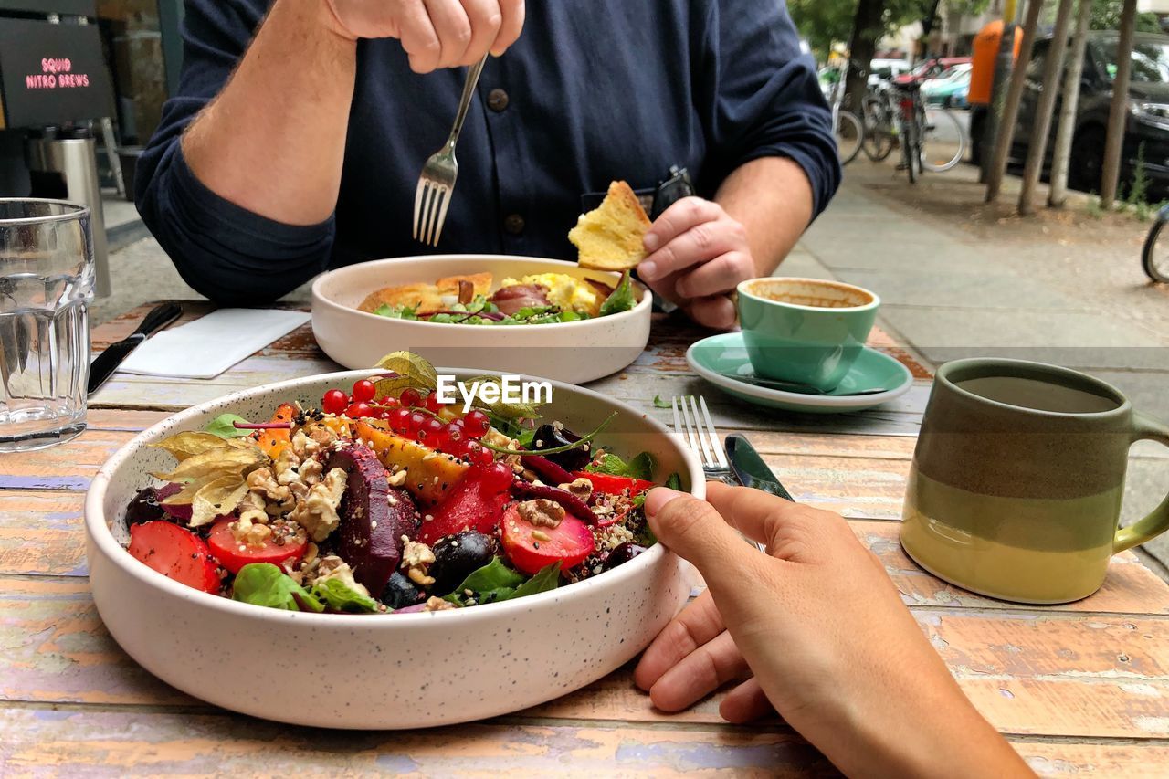 Midsection of man having vegan food with a woman