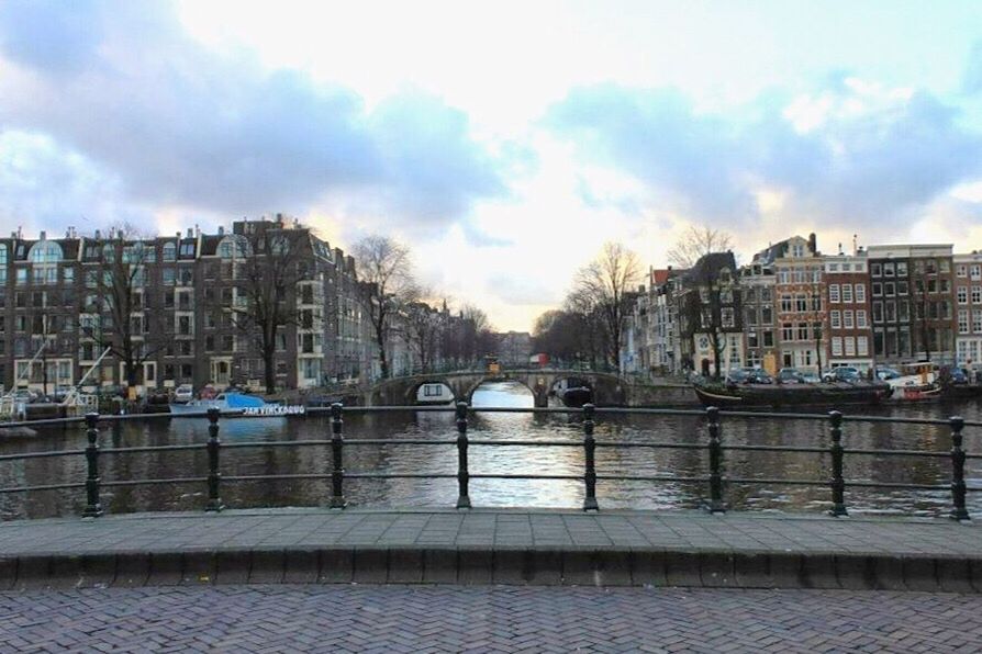 BRIDGE OVER RIVER WITH CITY IN BACKGROUND