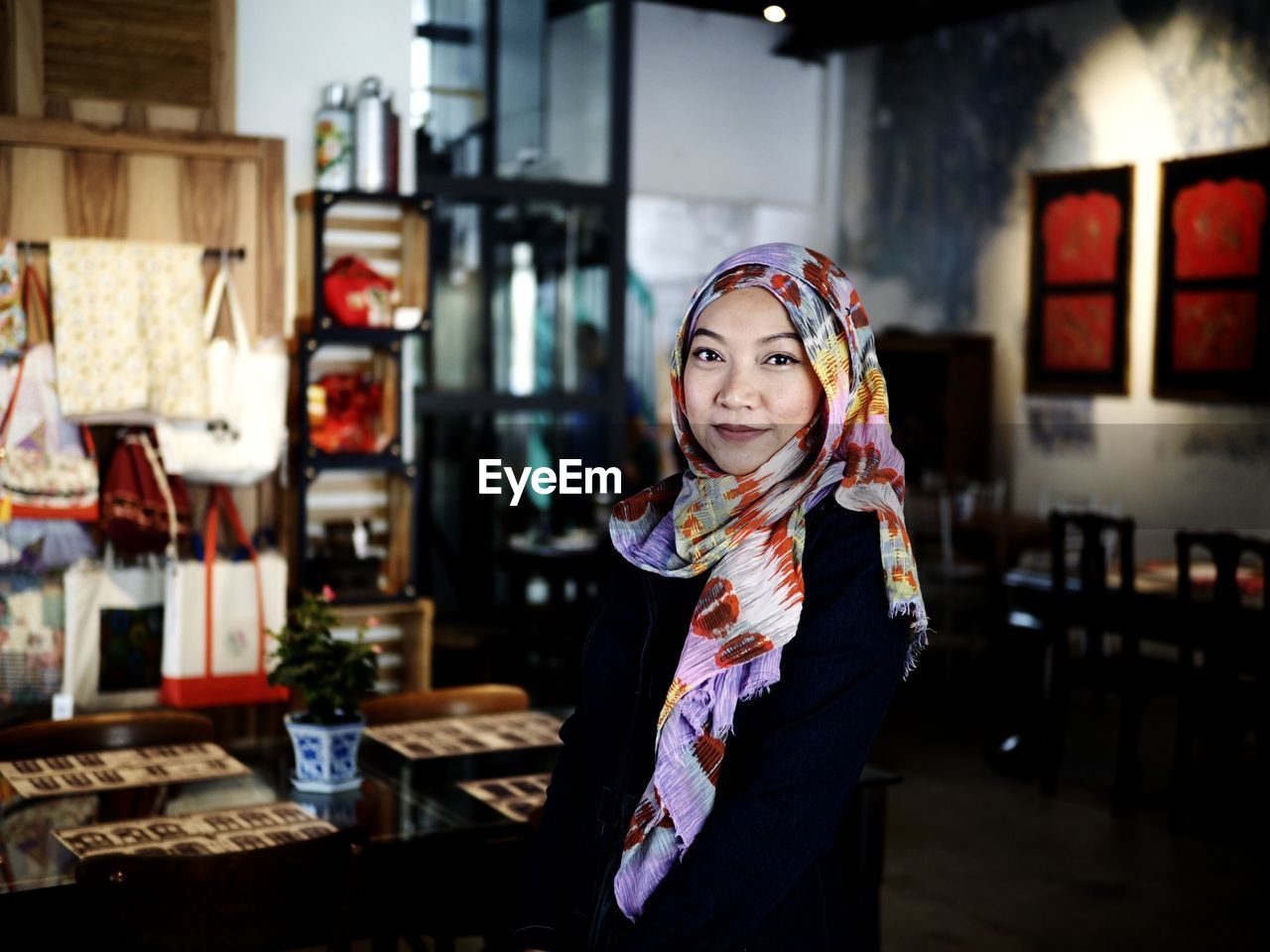 Portrait of smiling young woman standing in restaurant