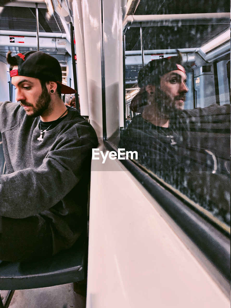 Young man looking through train window
