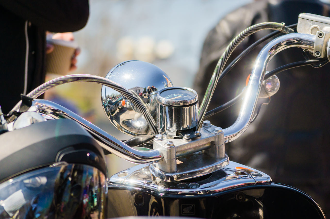 CLOSE-UP OF MOTORCYCLE WITH REFLECTION OF CARS