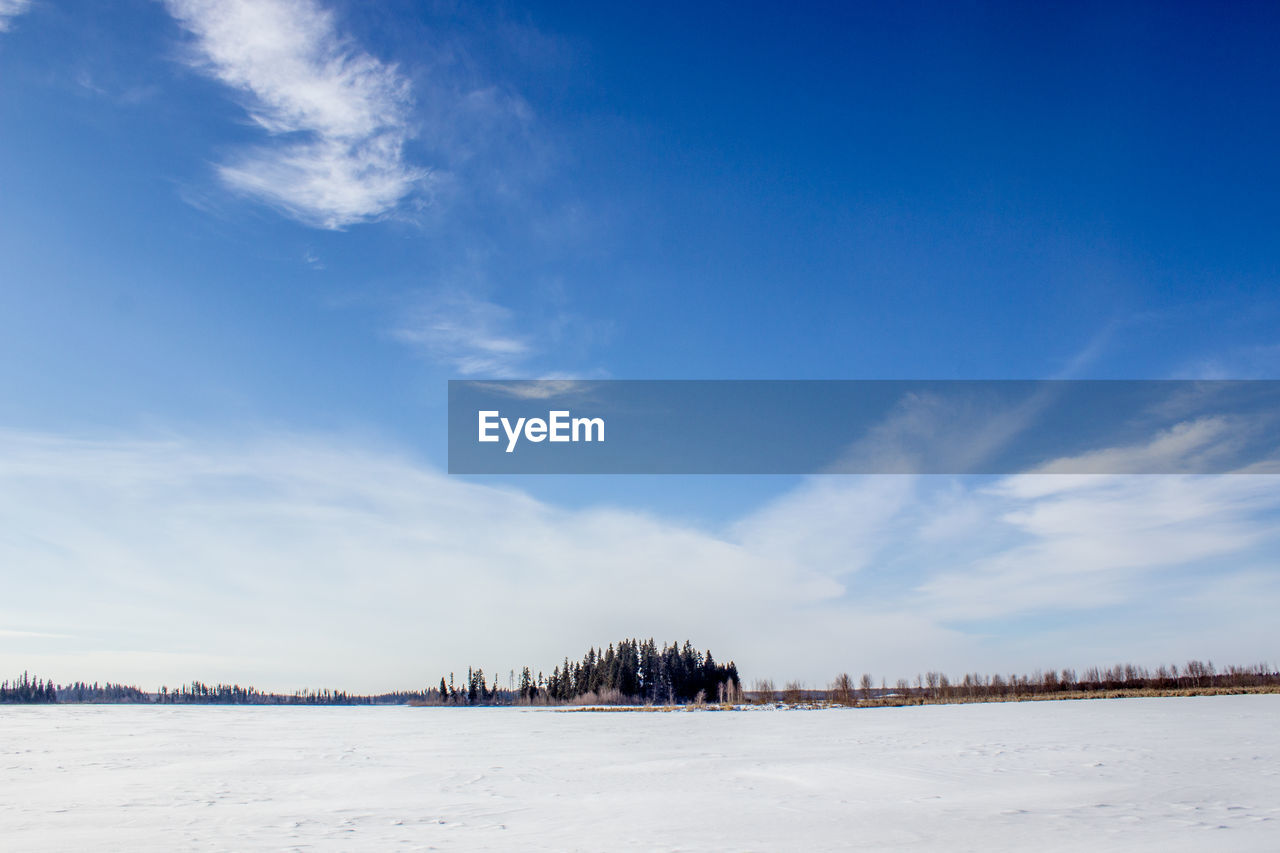 Scenic view of landscape against blue sky during winter