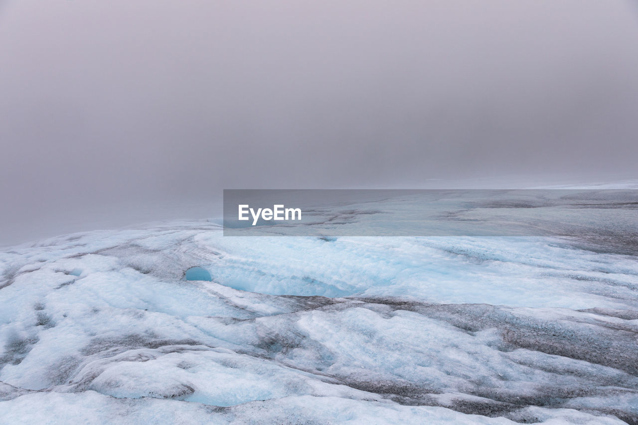 SCENIC VIEW OF FROZEN LANDSCAPE AGAINST SKY DURING WINTER