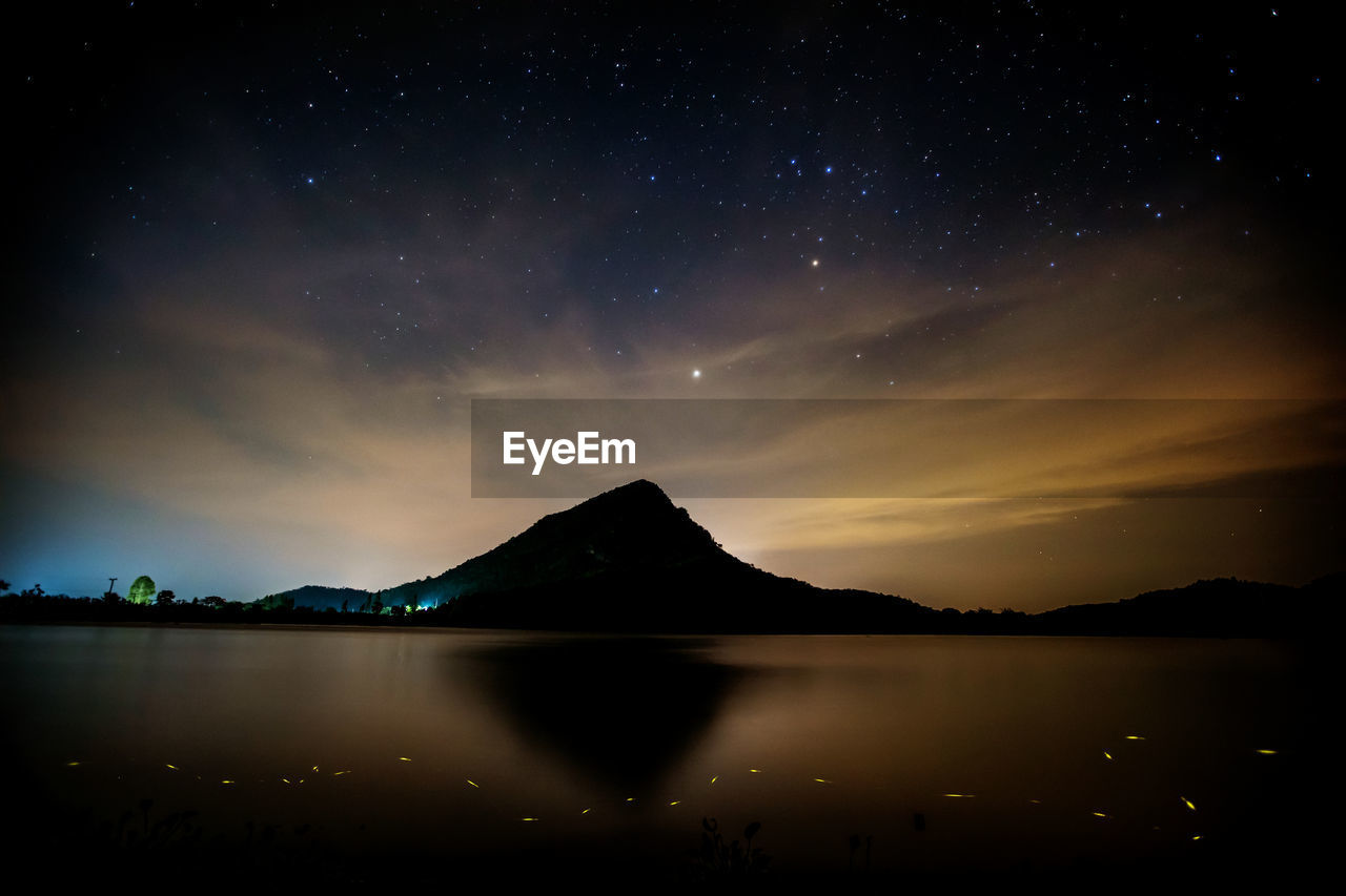 Scenic view of lake against sky at night