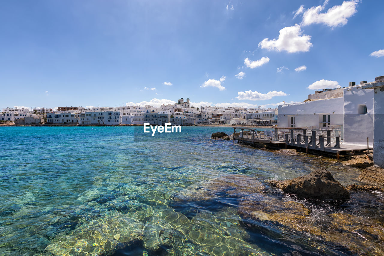 Scenic view of sea by buildings against sky