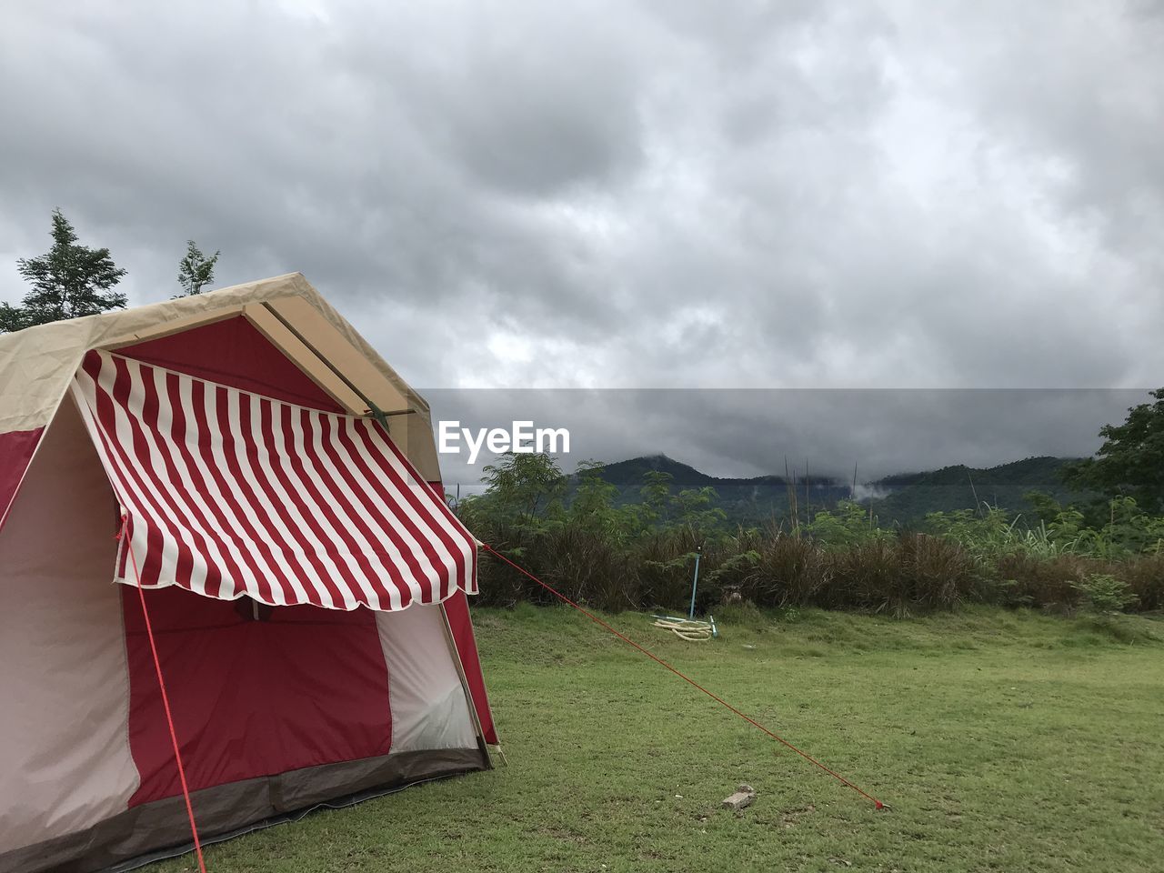 cloud, sky, nature, grass, tent, plant, environment, landscape, land, camping, overcast, no people, tree, architecture, scenics - nature, non-urban scene, mountain, beauty in nature, outdoors, day, storm cloud, rural scene, storm, house, tranquility, built structure, vacation, trip, field, holiday