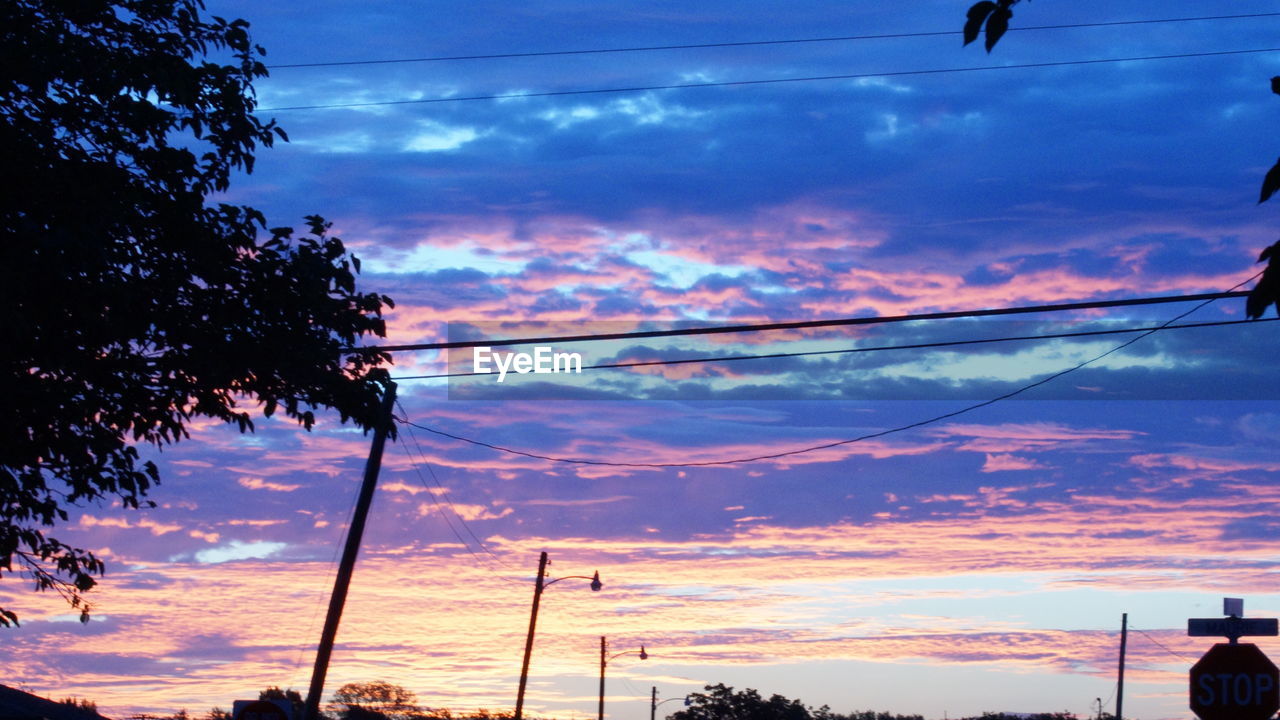 POWER LINES AGAINST CLOUDY SKY