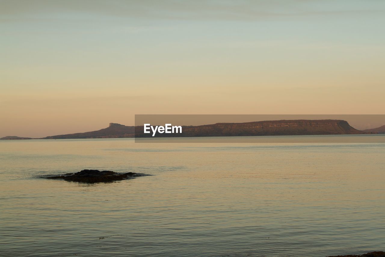 Scenic view of river and mountain against sky during sunset