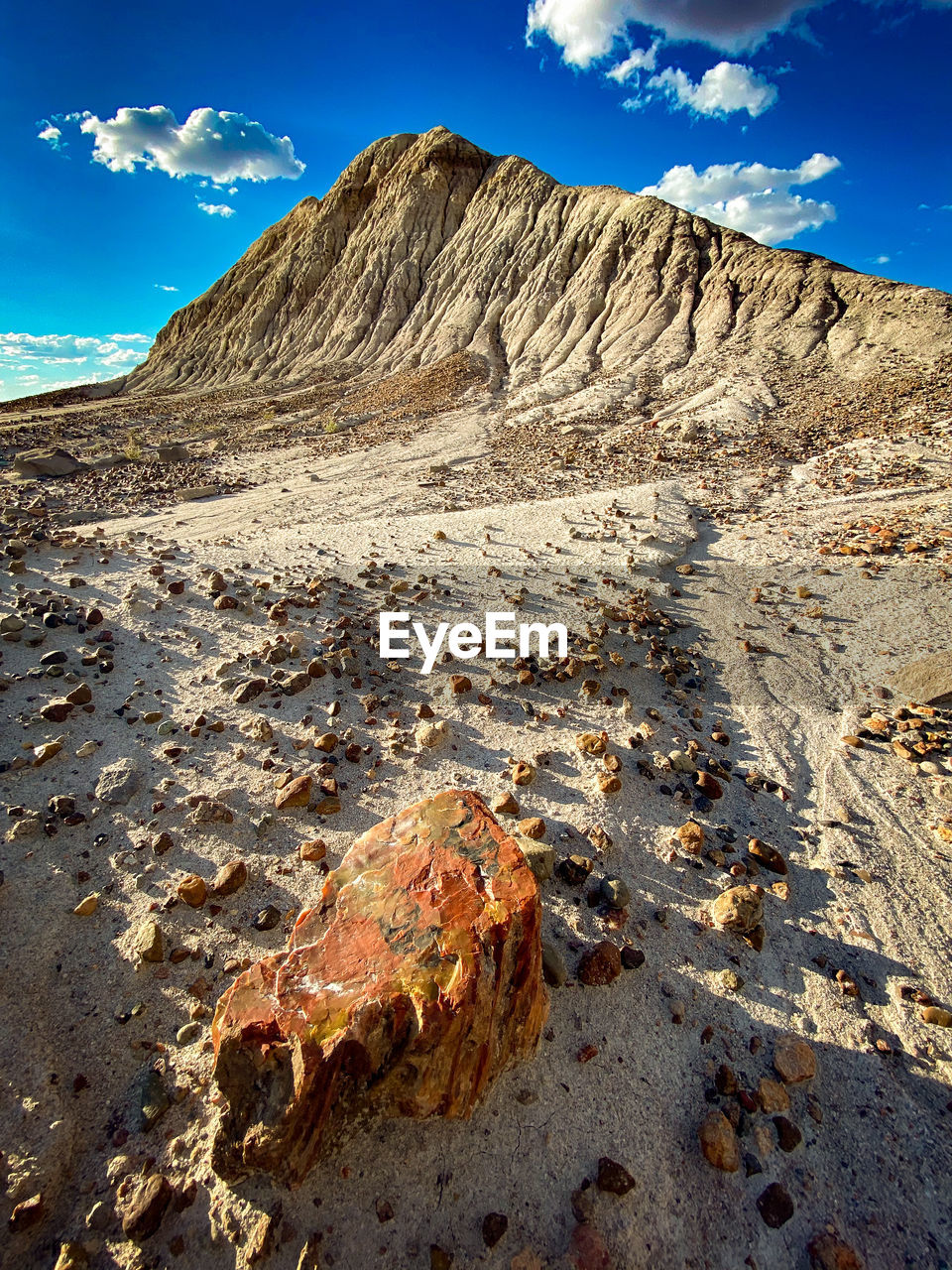 Scenic view of mountains against sky and petrified rock in the foreground.