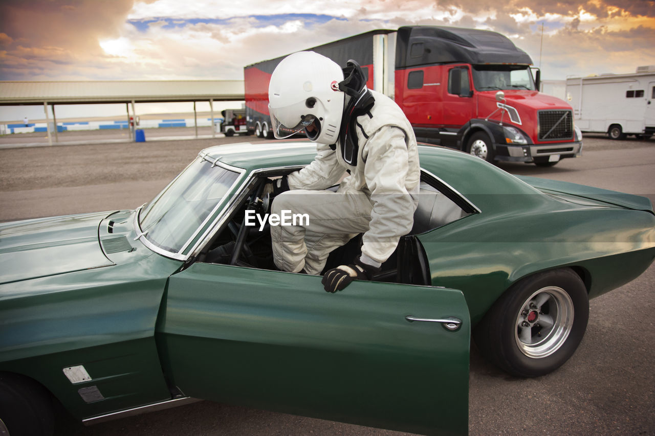 Sportsman sitting in vintage car while preparing for sports race