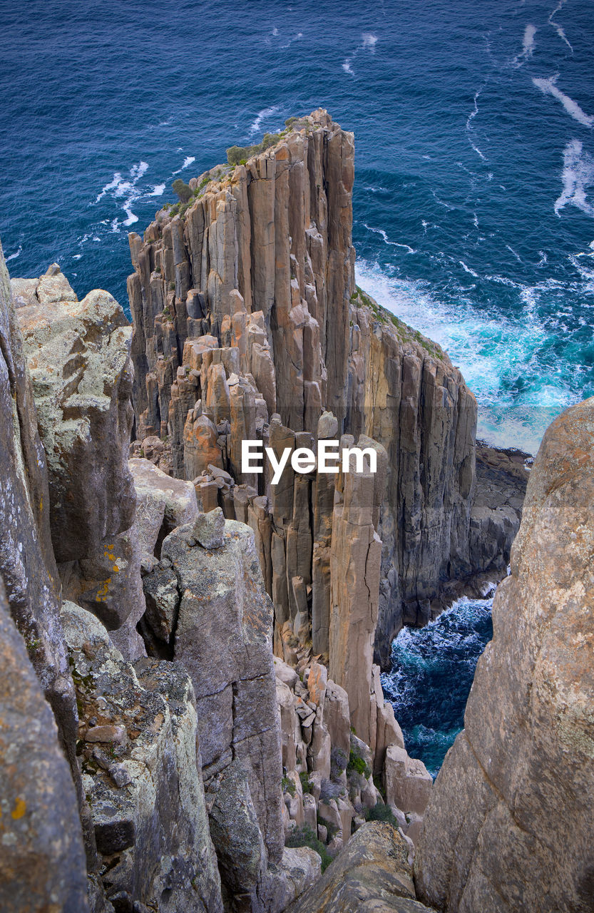 HIGH ANGLE VIEW OF ROCKS ON SHORE AT SEA