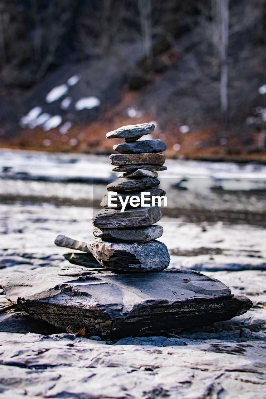 STACK OF STONES ON SNOW COVERED FIELD