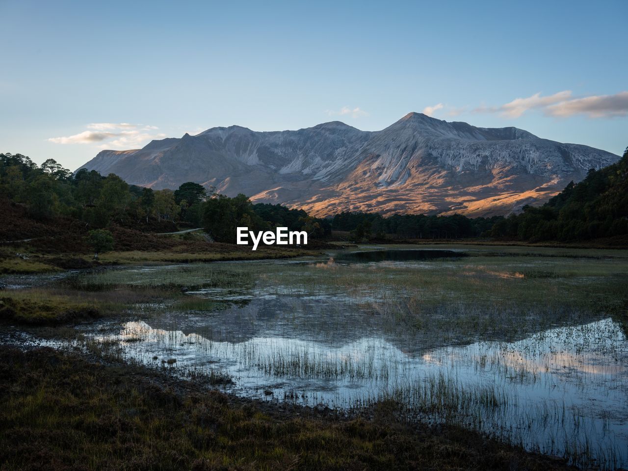 Scenic view of lake and mountains against sky during sunset