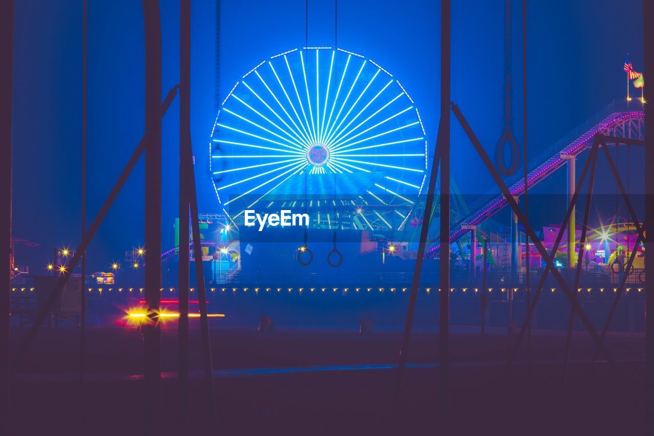 ILLUMINATED FERRIS WHEEL AGAINST BLUE SKY