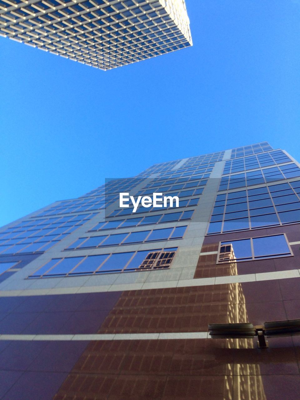 LOW ANGLE VIEW OF MODERN BUILDINGS AGAINST CLEAR BLUE SKY