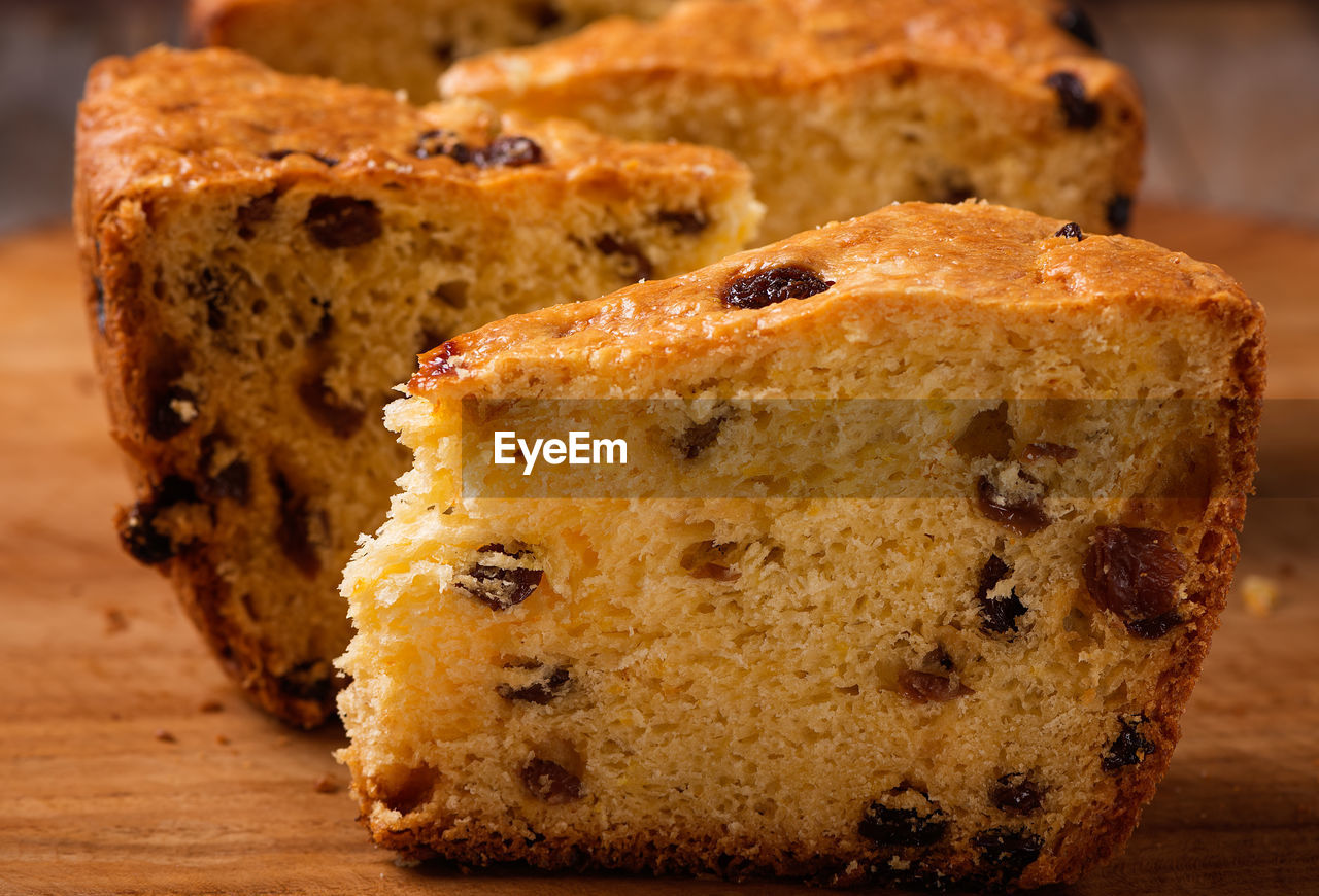 Slices of home made cake with raisins on wooden plate close up
