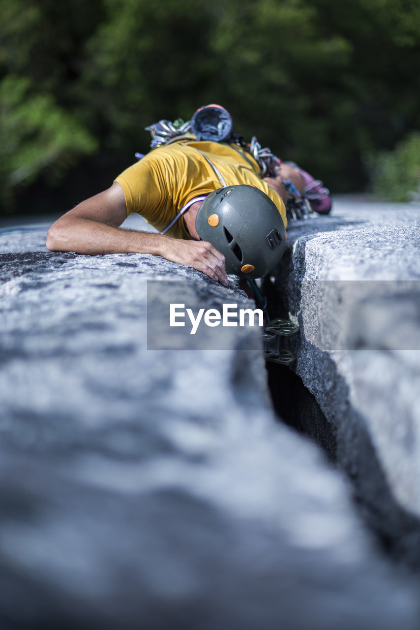 Man placing protection while climbing wide crack on granite squamish
