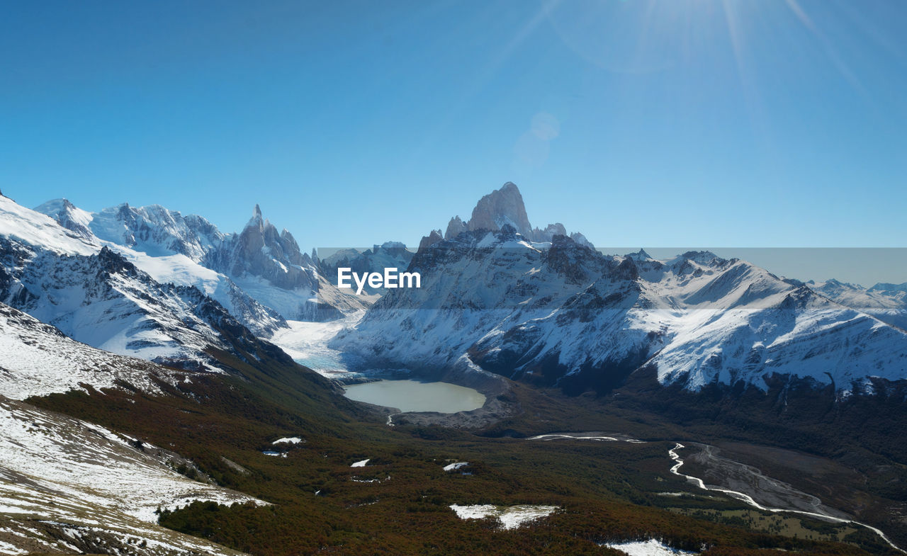 Scenic view of snowcapped mountains against clear blue sky