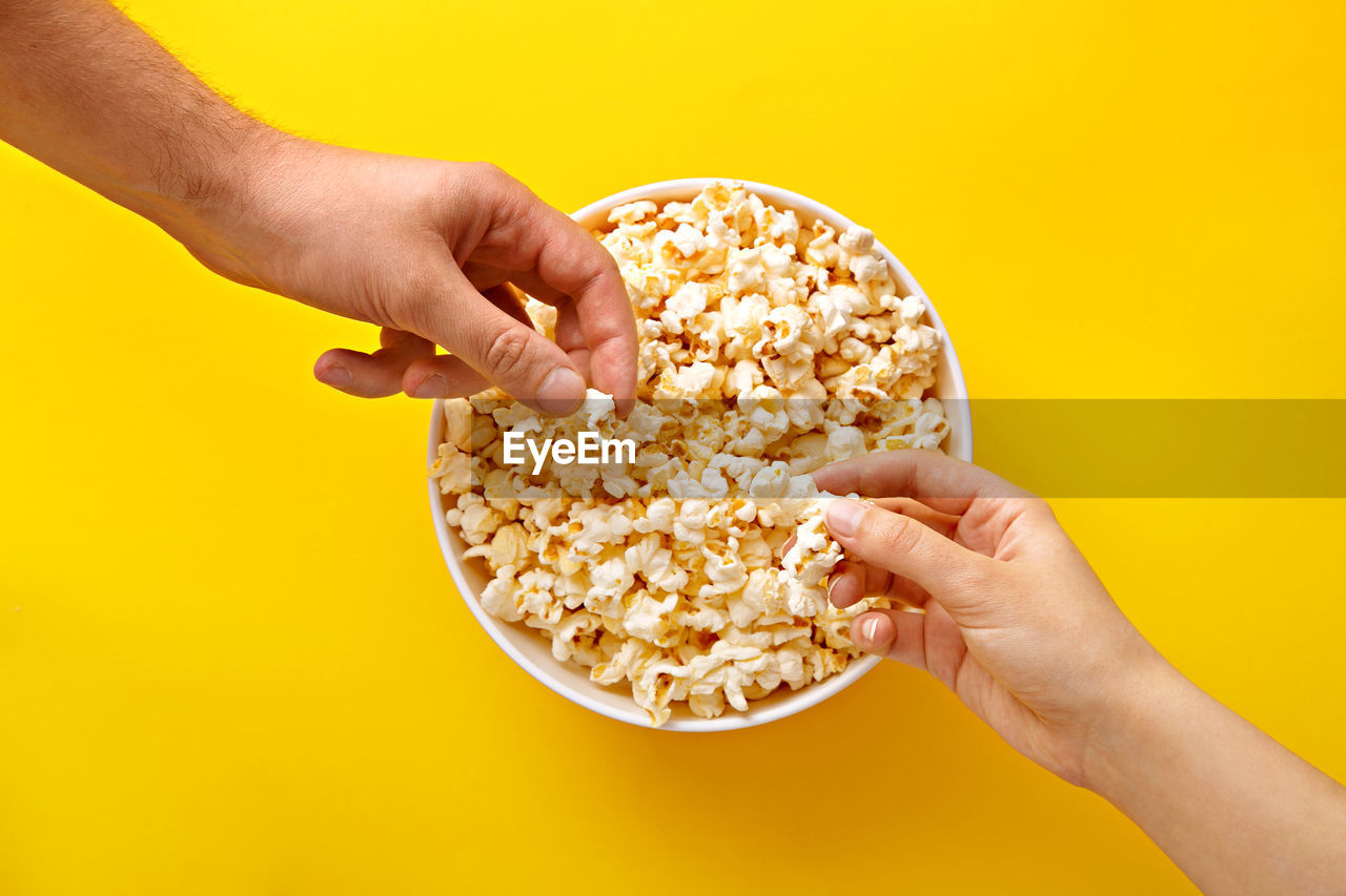 Close-up of hands holding popcorn