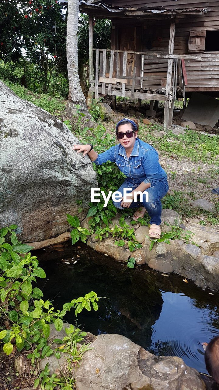 High angle view of woman crouching by pond