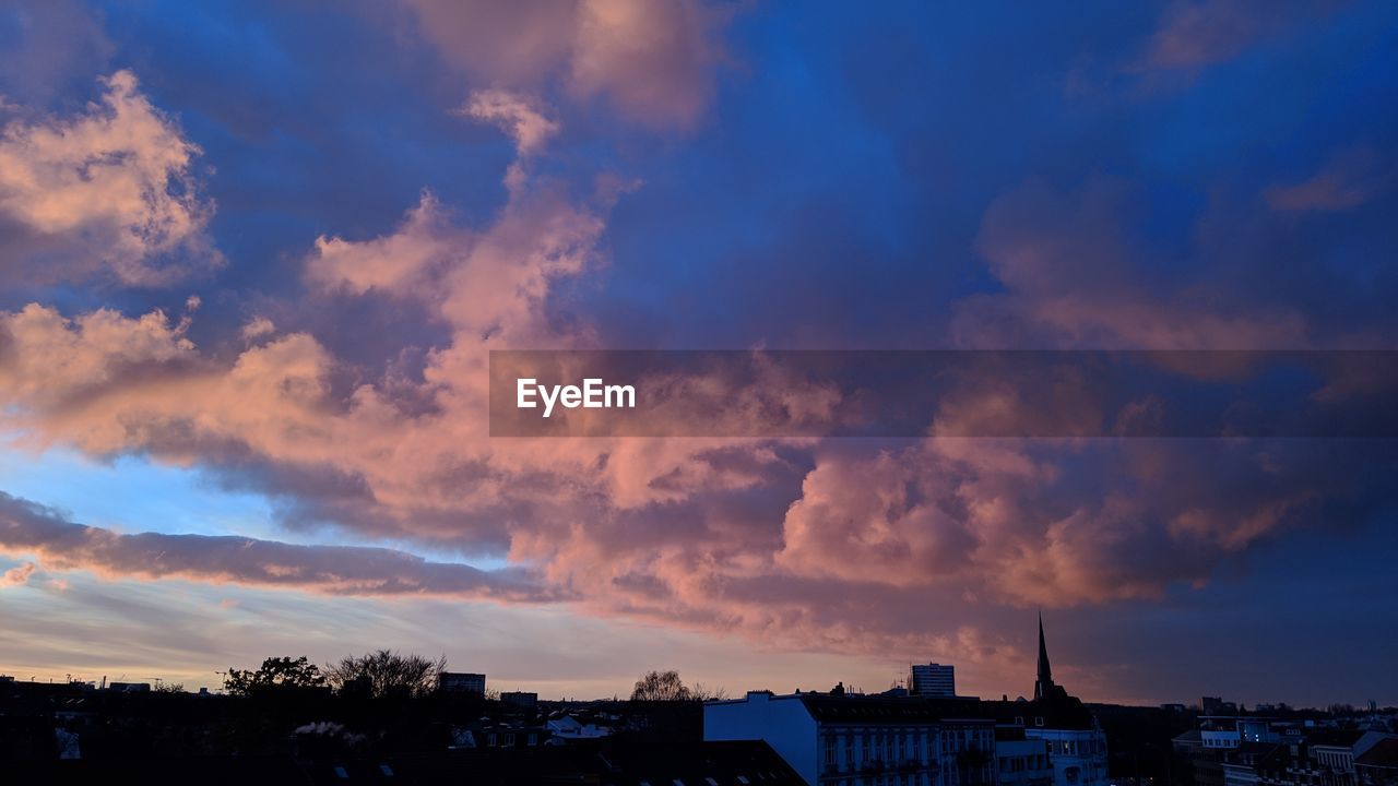 Low angle view of buildings against dramatic sky