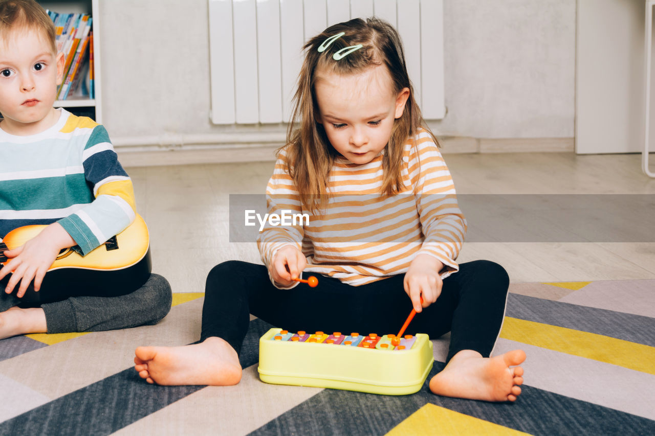 Child at home learning to play the xylophone. leisure and education at home