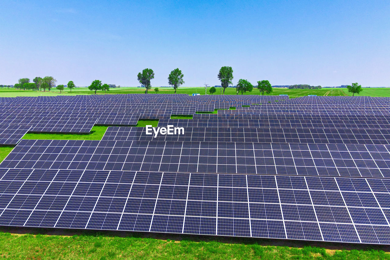 Solar panels in green field, aerial view