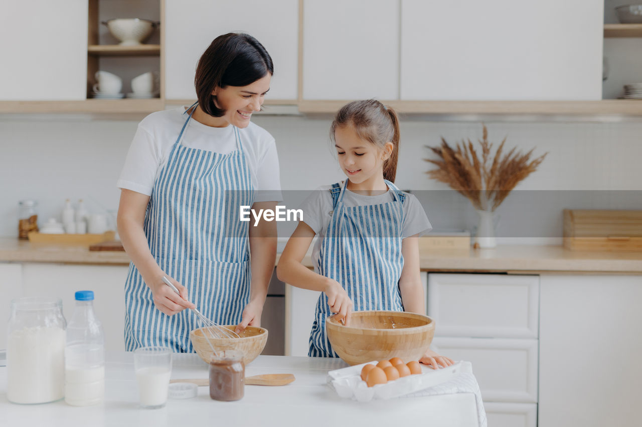 Mother and daughter preparing food at home