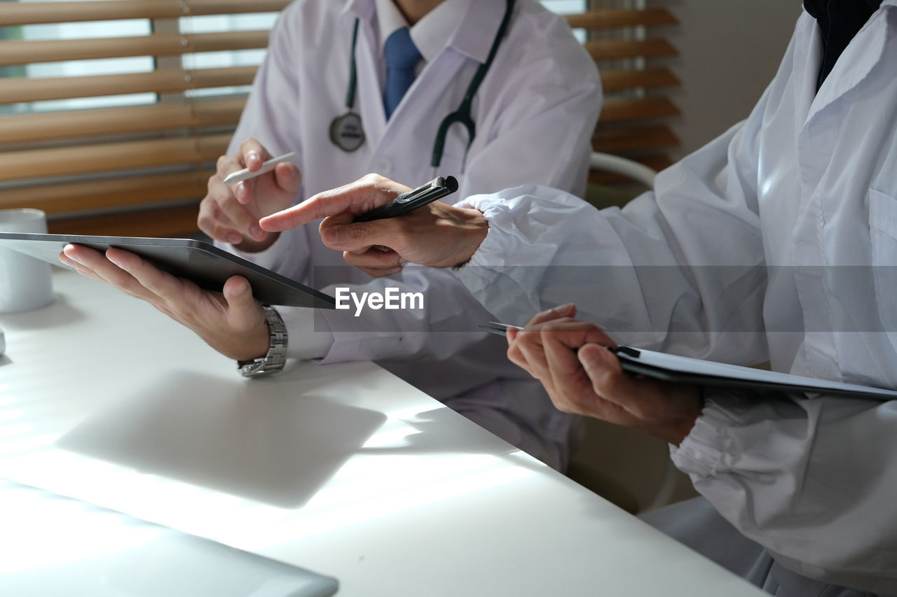 midsection of doctor examining patient at clinic