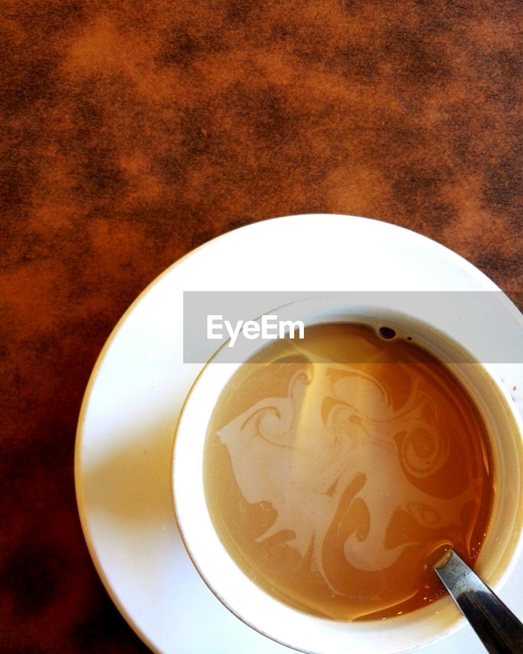 DIRECTLY ABOVE SHOT OF COFFEE CUP ON TABLE WITH SPOON