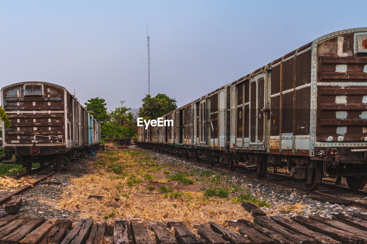 TRAIN ON RAILROAD TRACK AGAINST CLEAR SKY