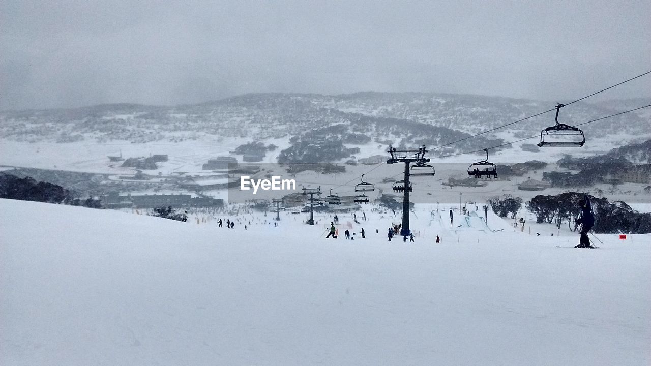 VIEW OF SKI LIFT OVER SNOW COVERED MOUNTAINS