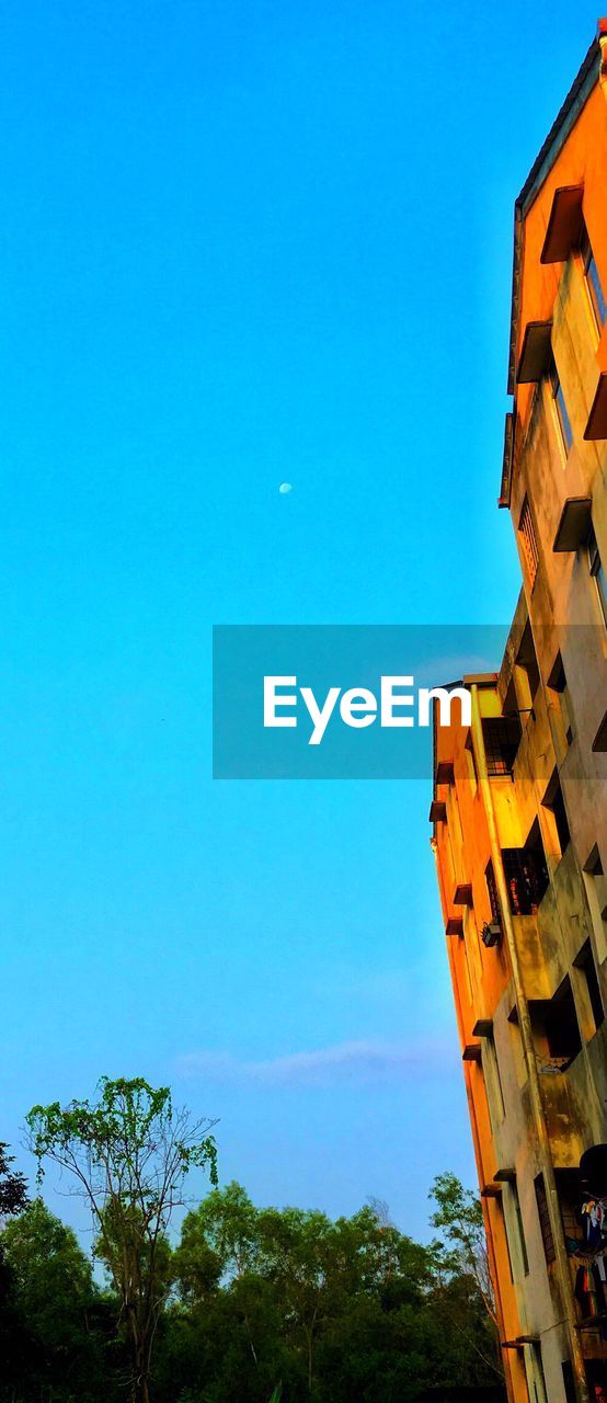 LOW ANGLE VIEW OF BUILDINGS AGAINST CLEAR BLUE SKY