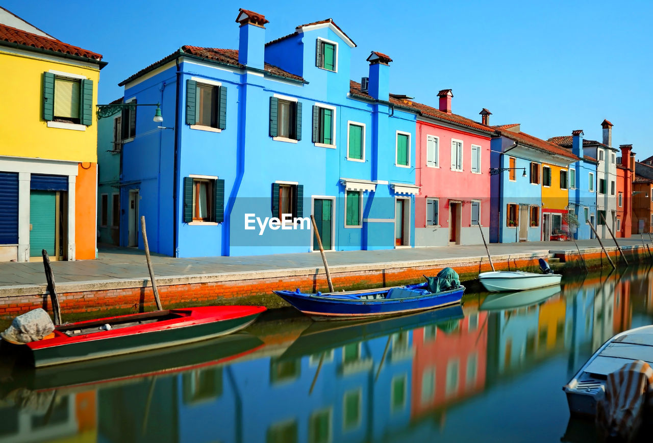 Burano isalnd near venice in italy and reflection over the navigable waterway of the colorful houses