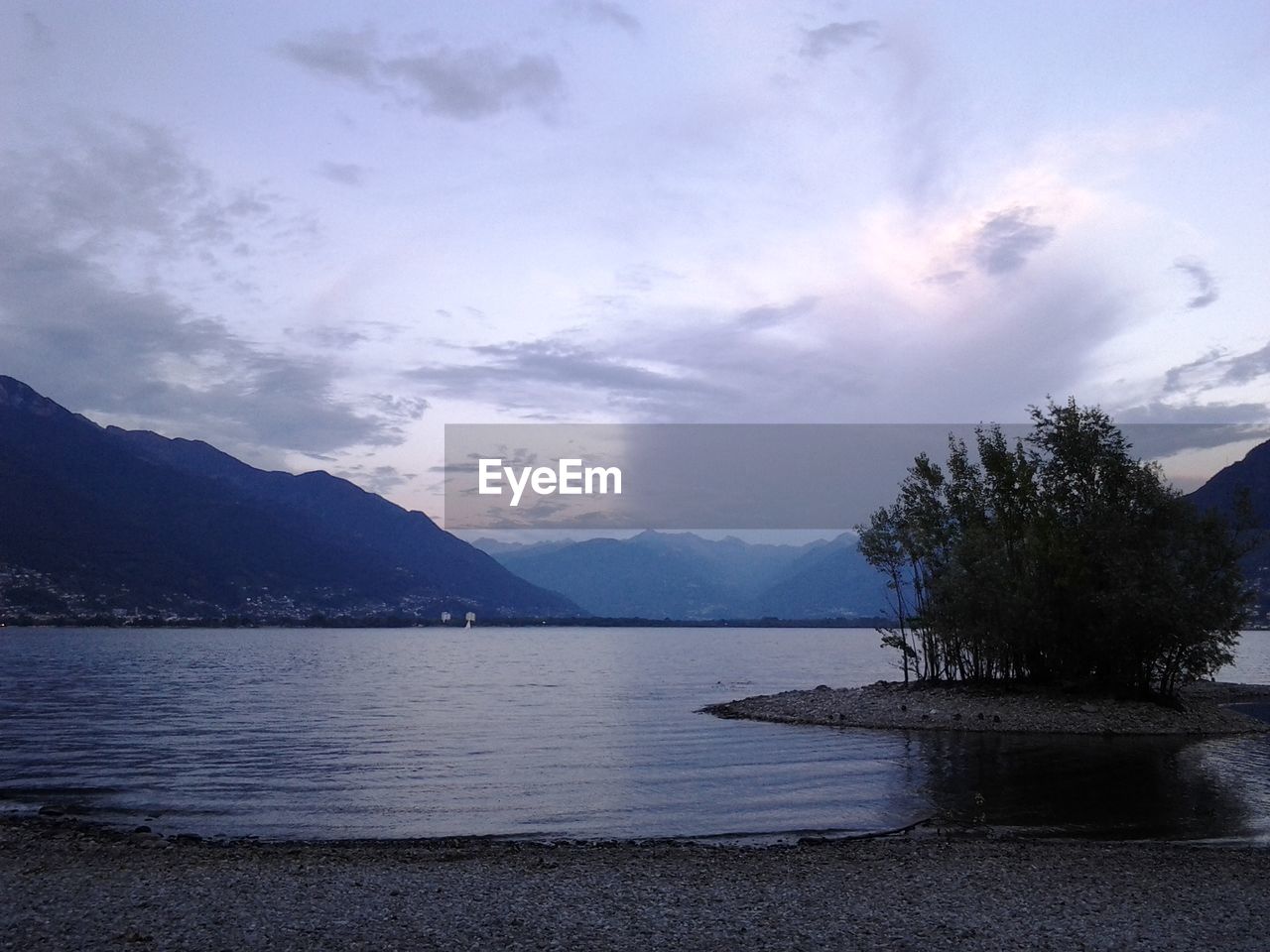 SCENIC VIEW OF LAKE BY MOUNTAIN AGAINST SKY