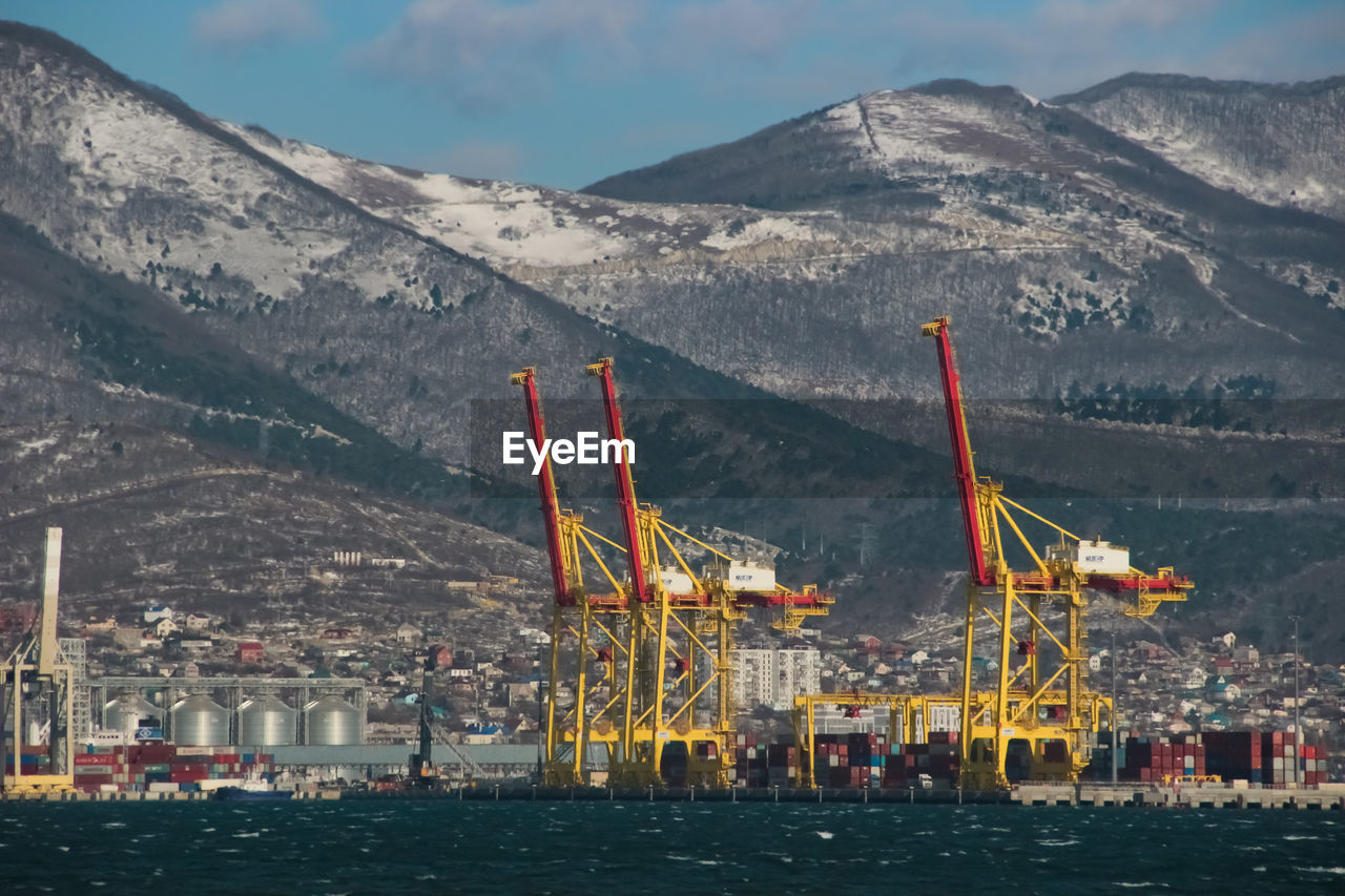 Scenic view of sea by mountains against sky