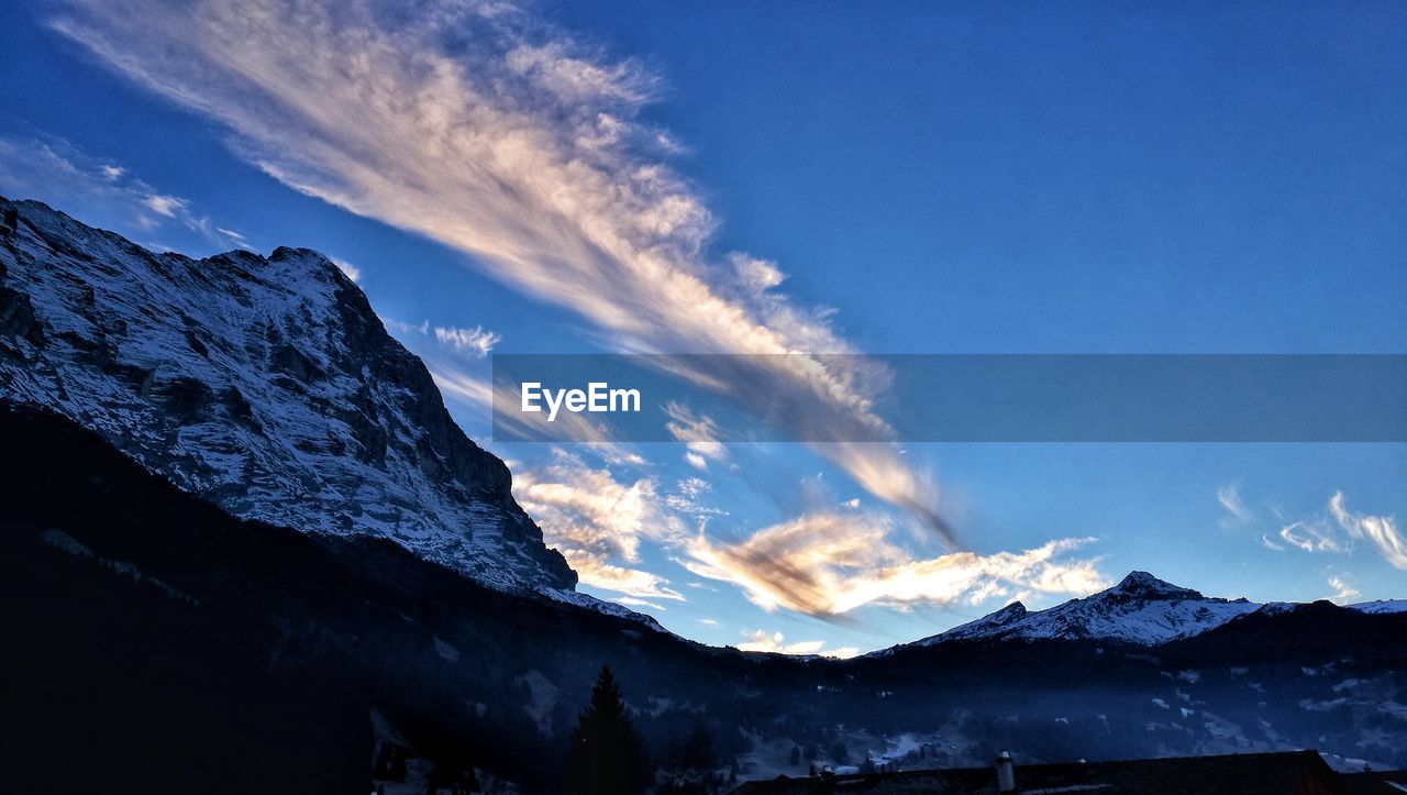 Scenic view of snowcapped mountains against blue sky