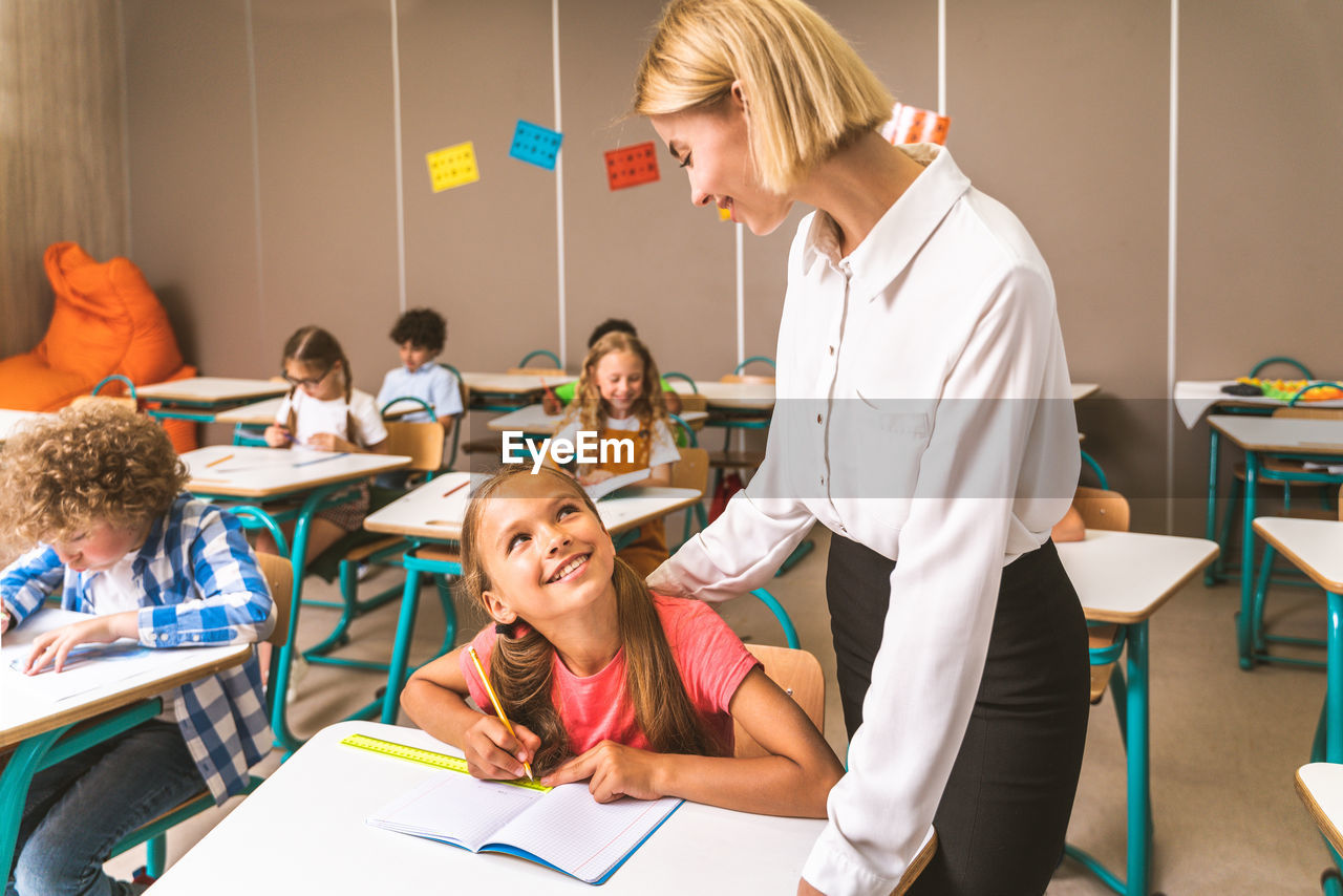 Teacher teaching student at classroom