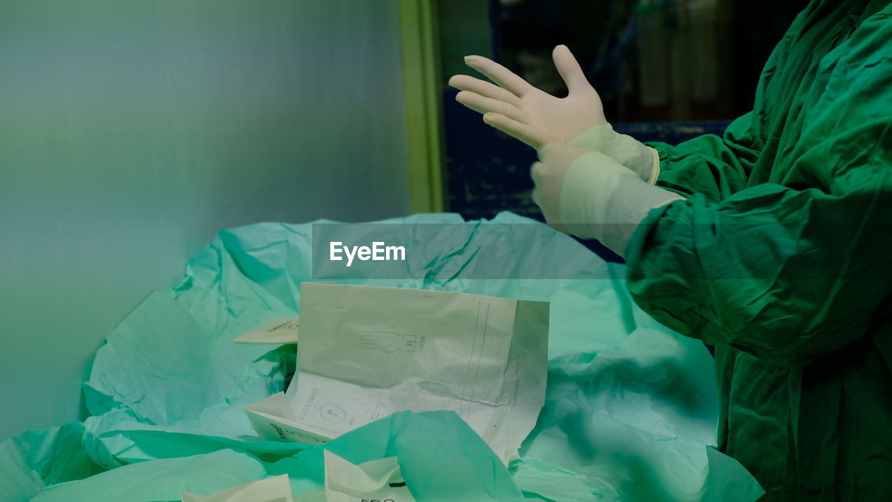 Close-up on surgeon wearing a sterile surgical gloves under aseptic precaution. 