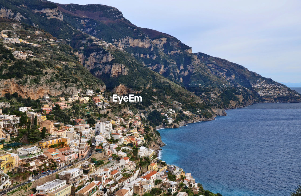 Coastal town on hill with sea against sky